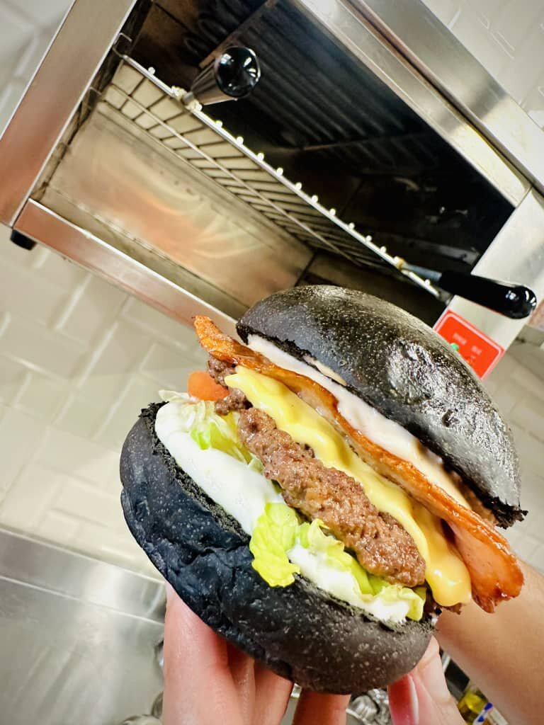 Burger pain noir présenté à la main